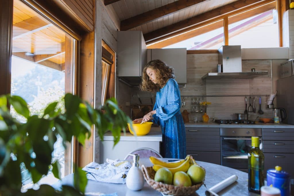 woman in blue dress holding a yellow bowl