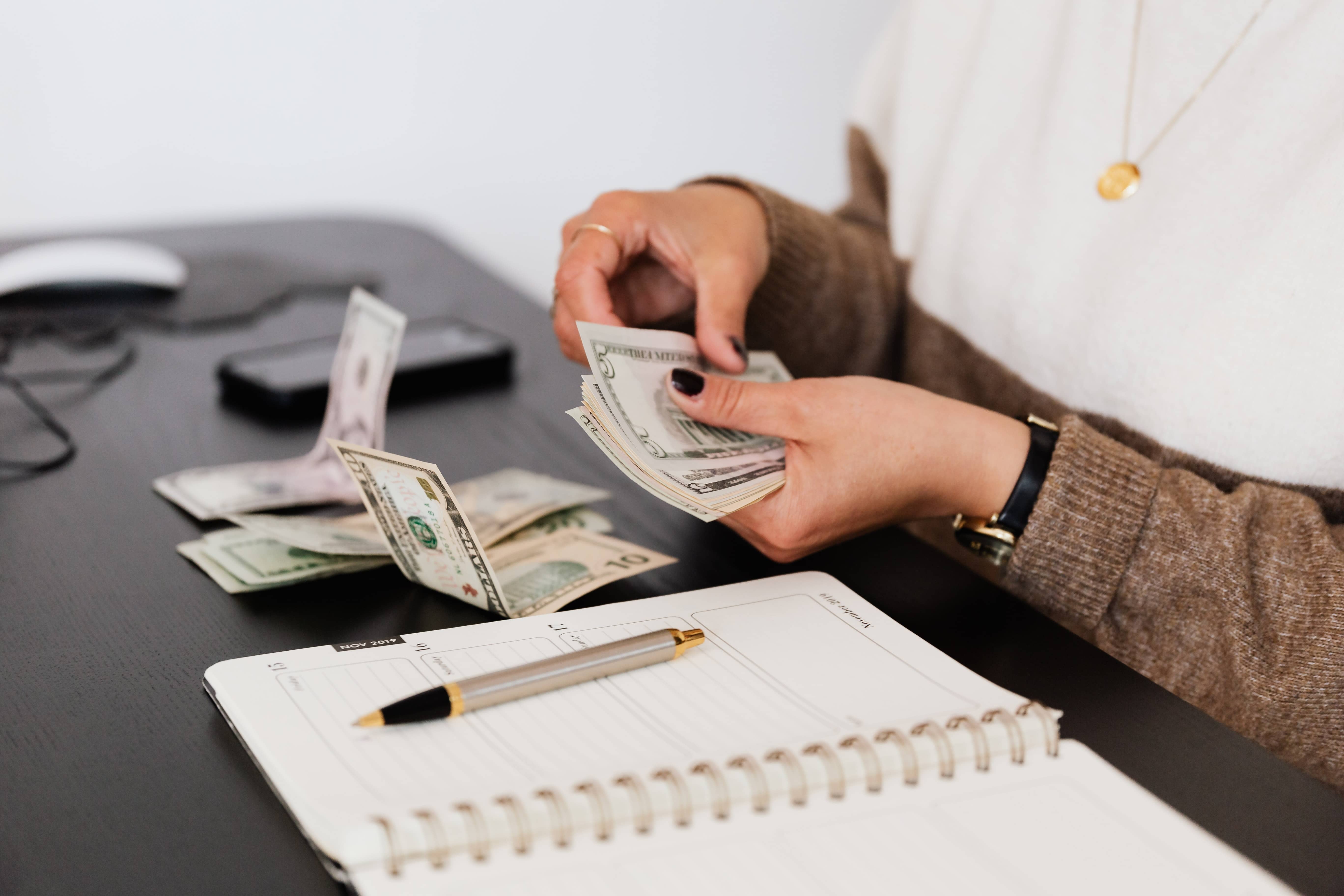 woman counting money on table