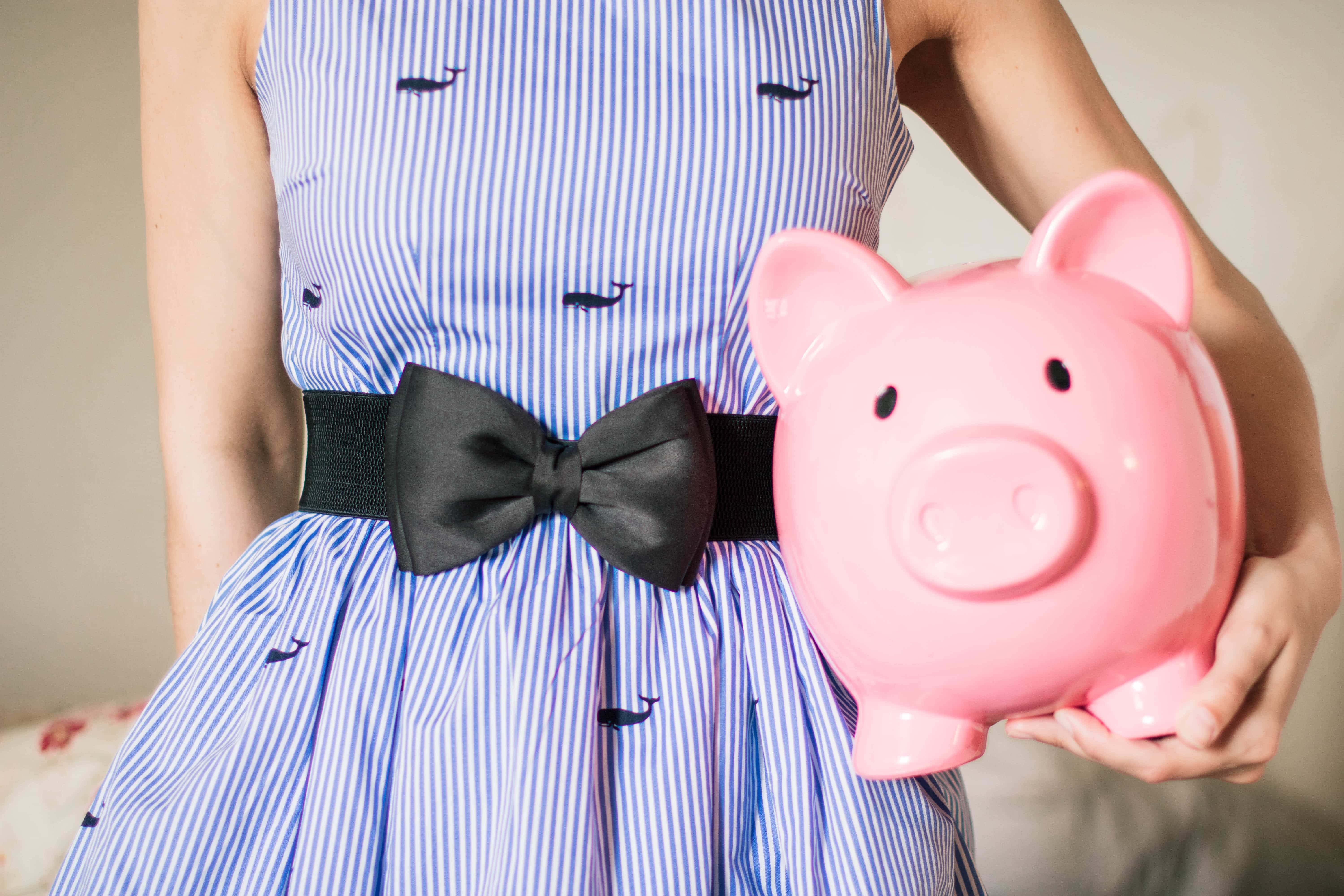 lady in a striped dress carrying a piggy bank