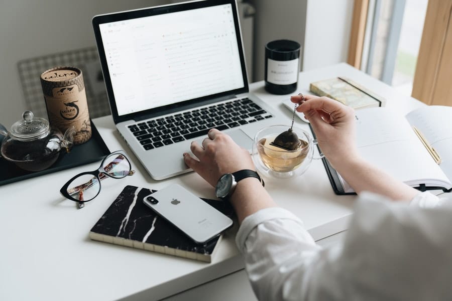 A woman making a cup of tea while working