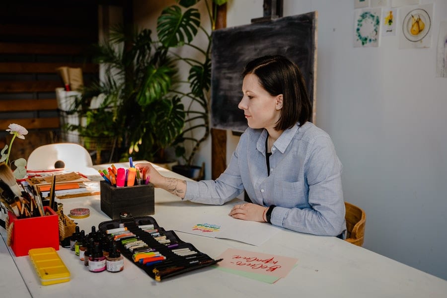 photo of woman in blue shirt sitting by the table