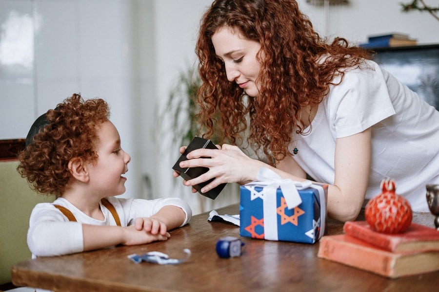 A mother handing a gift to her son