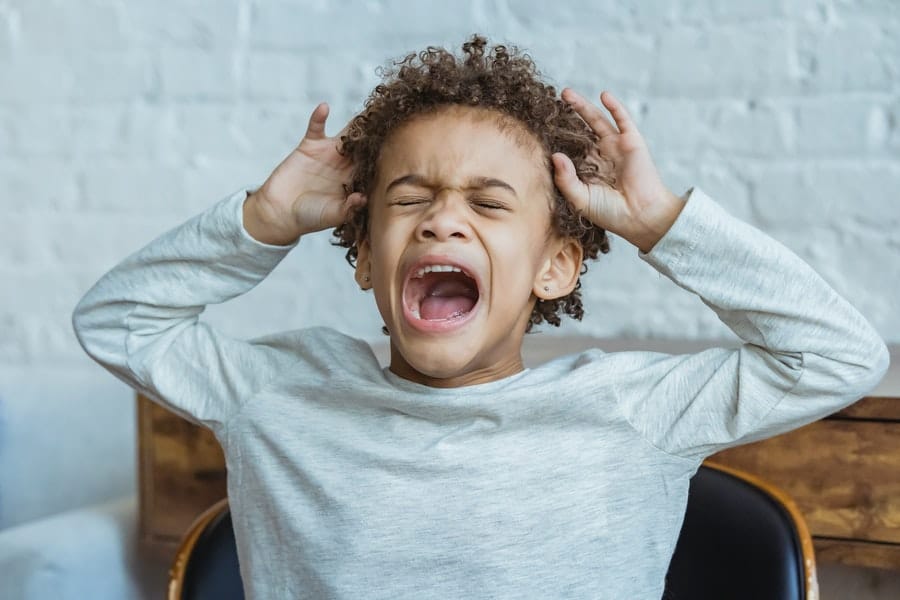 A kid screaming on a chair