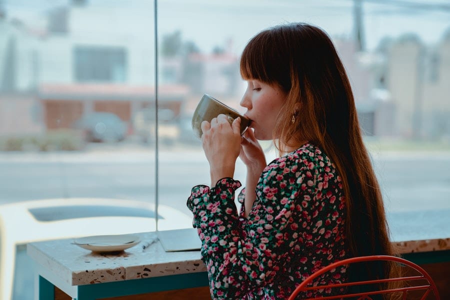 A woman taking a break by sipping a coffee