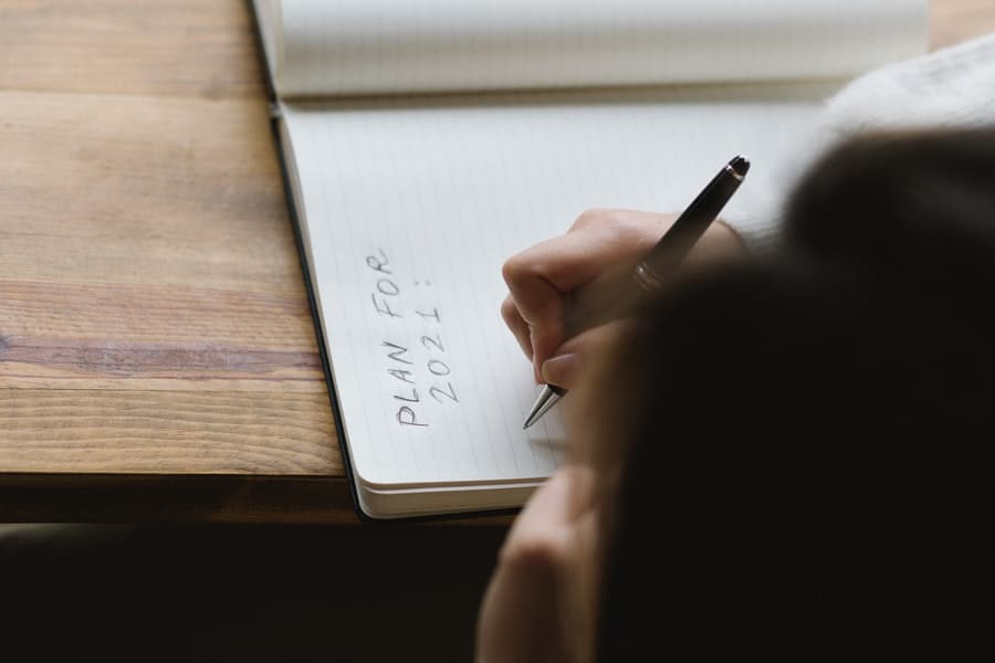 Woman writing plans on notebook