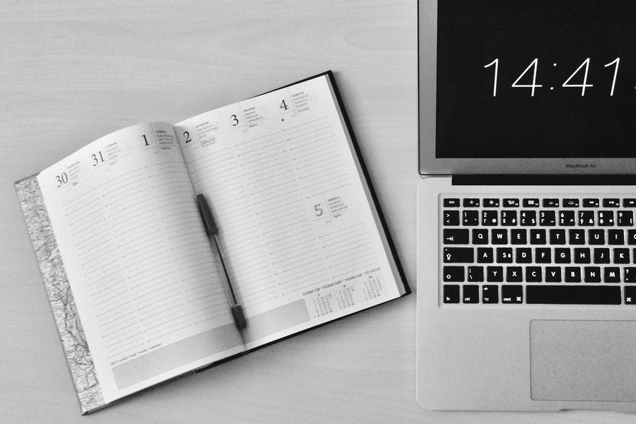 Black and white photo of notebook and laptop