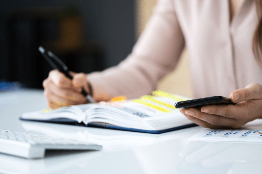 A lady writing down on her notebook