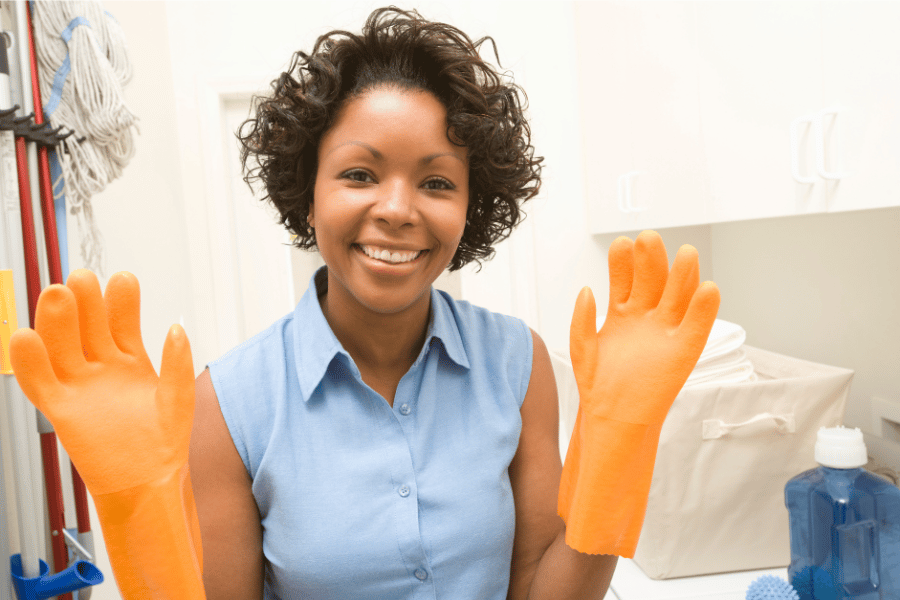A smiling lady wearing orange gloves
