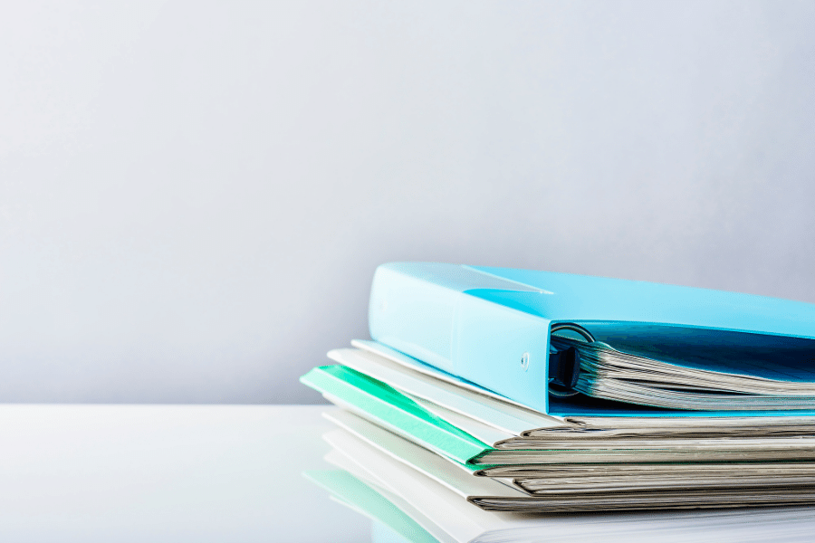 A few folders piled containing documents