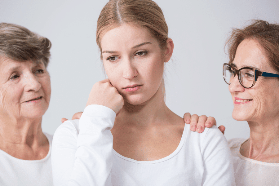 a sad-looking lady comforted by her family