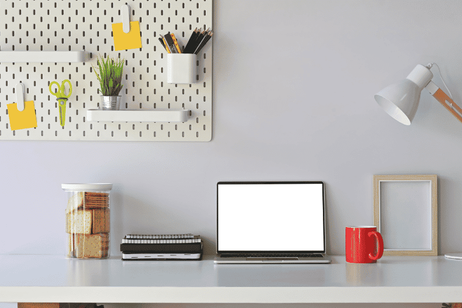 a simple work space with wall decor and table lamp