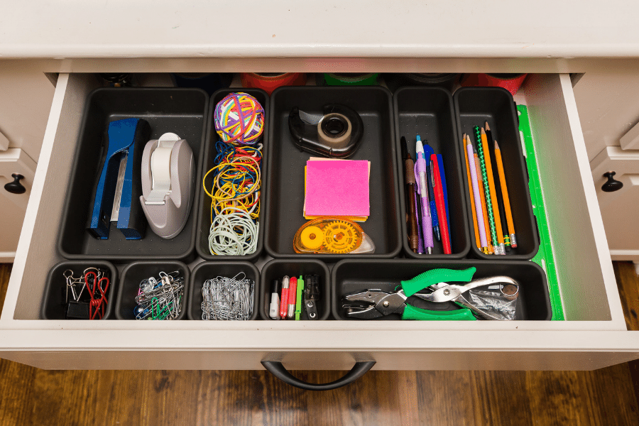 Office supplies organized in a desk drawer