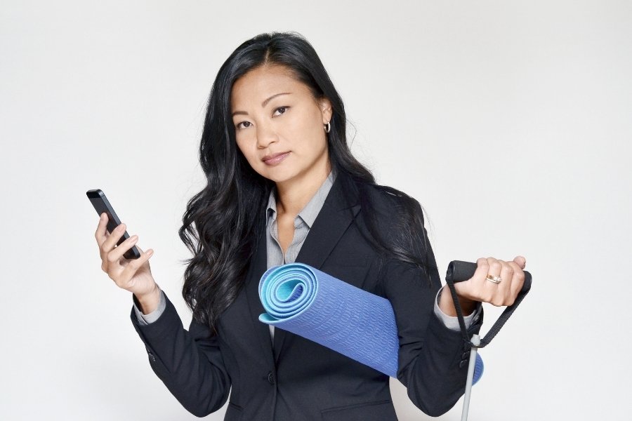 woman holding a phone, and yoga mat
