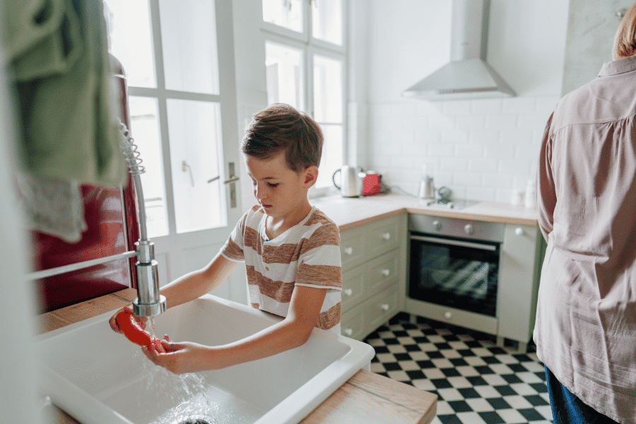 A kid washing the dish