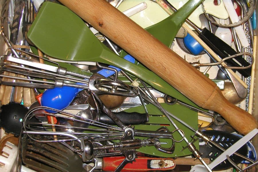 kitchen tools and utensils all mixed in the drawer